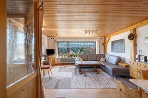 Una sala de estar acogedora con sofá, mesa de centro y televisor.