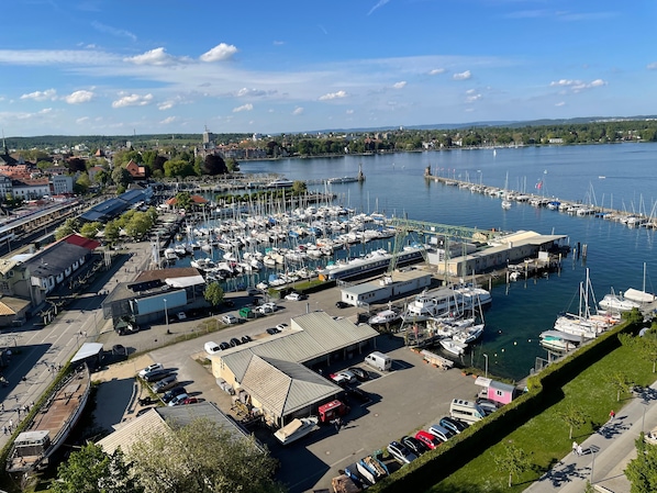 A marina with boats docked, a train station, and a building with a sloped roof.