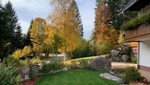 Ein gepflegter Garten mit Rasen, einem Weg und verschiedenen Bäumen.