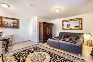 Una habitación con cama, un armario, un cuadro y un espejo.