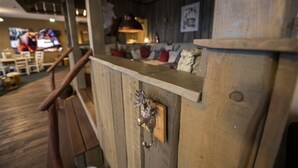 A wooden interior with a rustic design, including a wooden door with a metal handle and a wooden counter with a shelf. - Apartment Central Leipzig-Zoo (Leipzig)