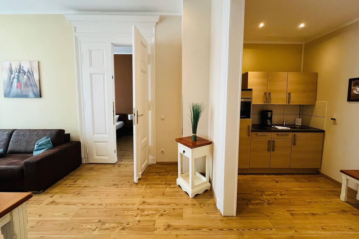A modern apartment with a living room, a hallway, and a kitchen.