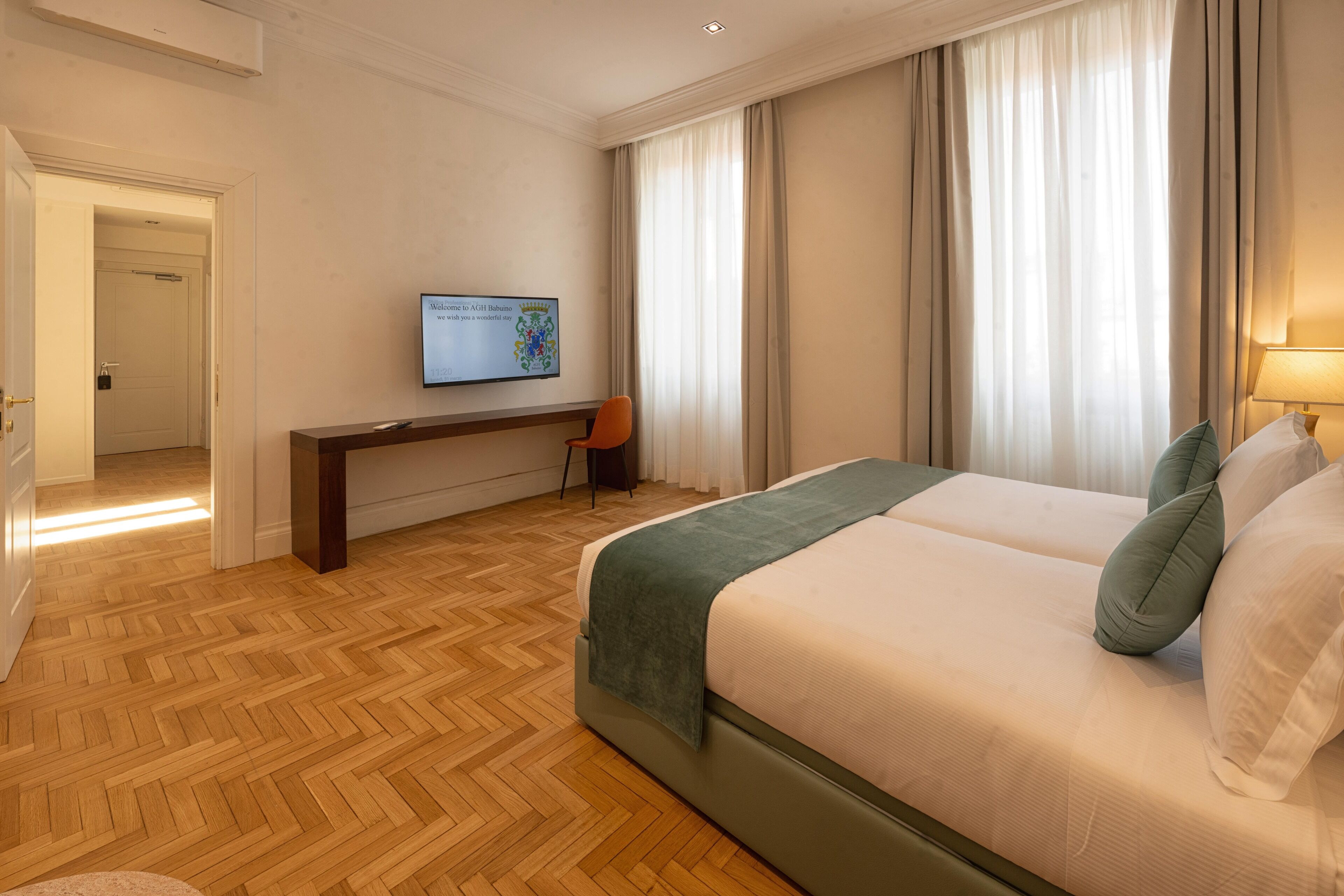 A hotel room with a bed, a desk, and a television.