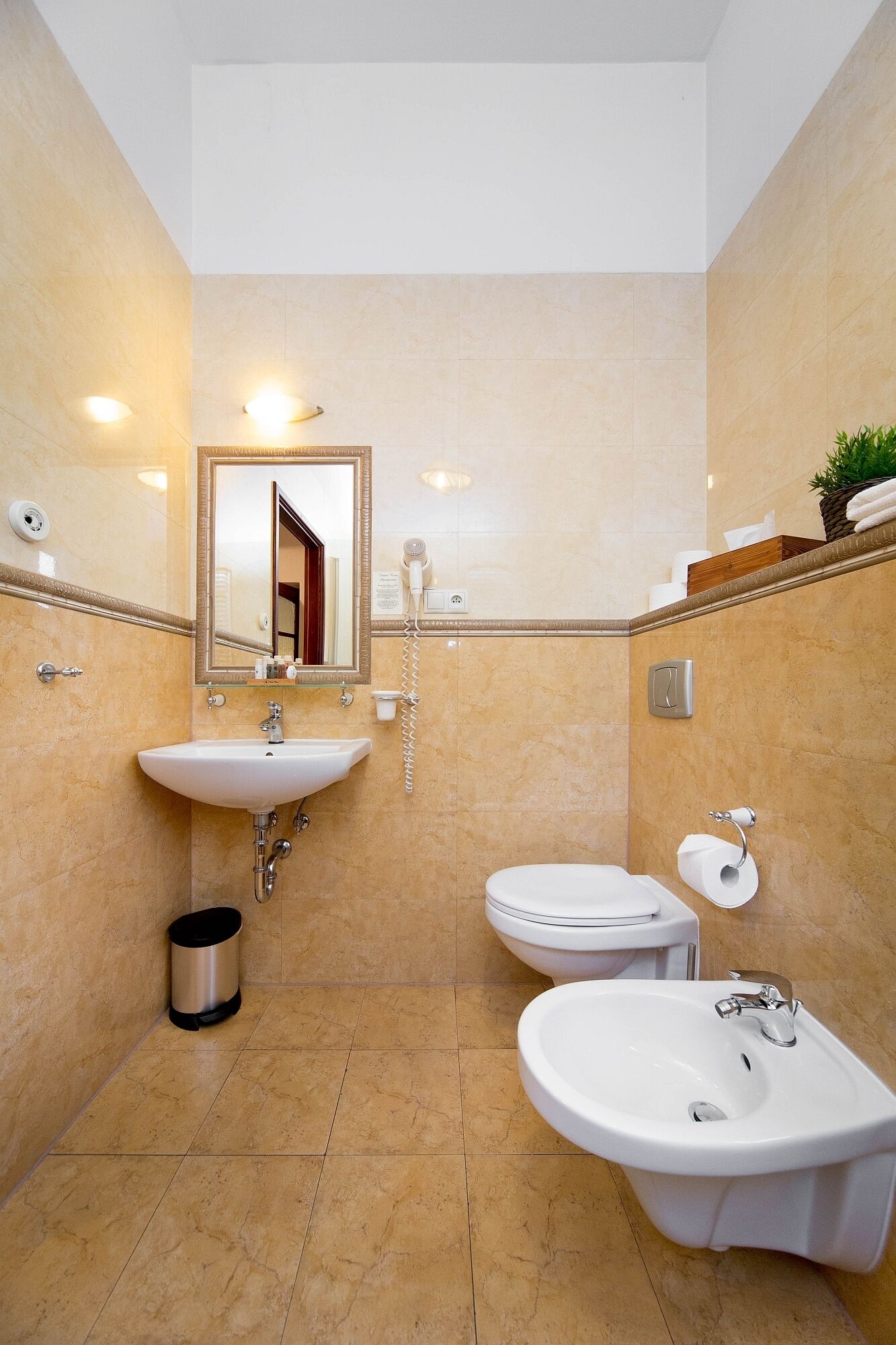Een moderne badkamer met een wastafel, toilet en bidet.