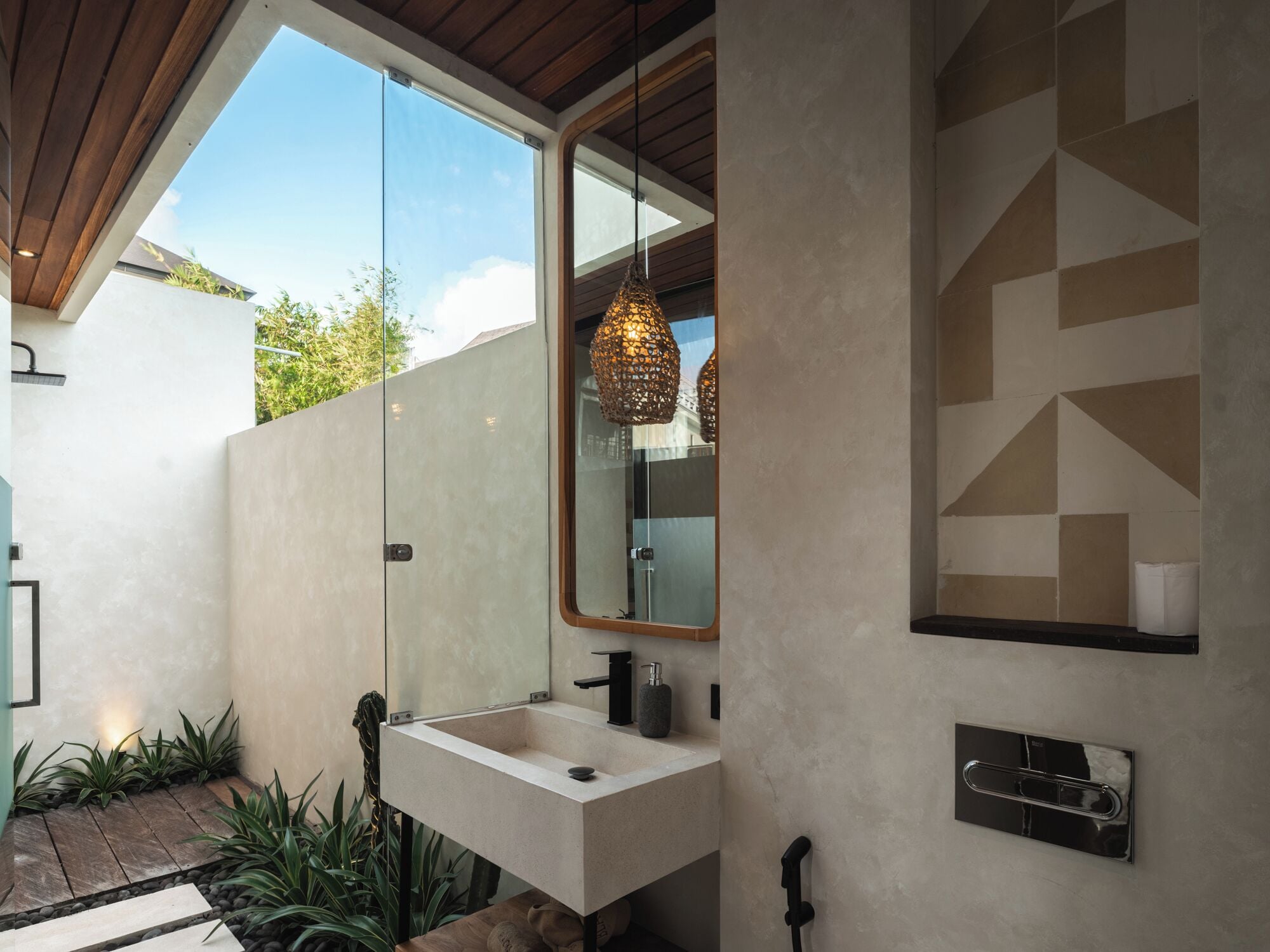 A modern bathroom with a large window, a sink, a mirror, and a hanging light fixture.