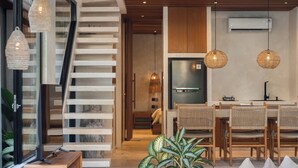 Una cocina moderna con una isla central, sillas de madera y una mesa de comedor.