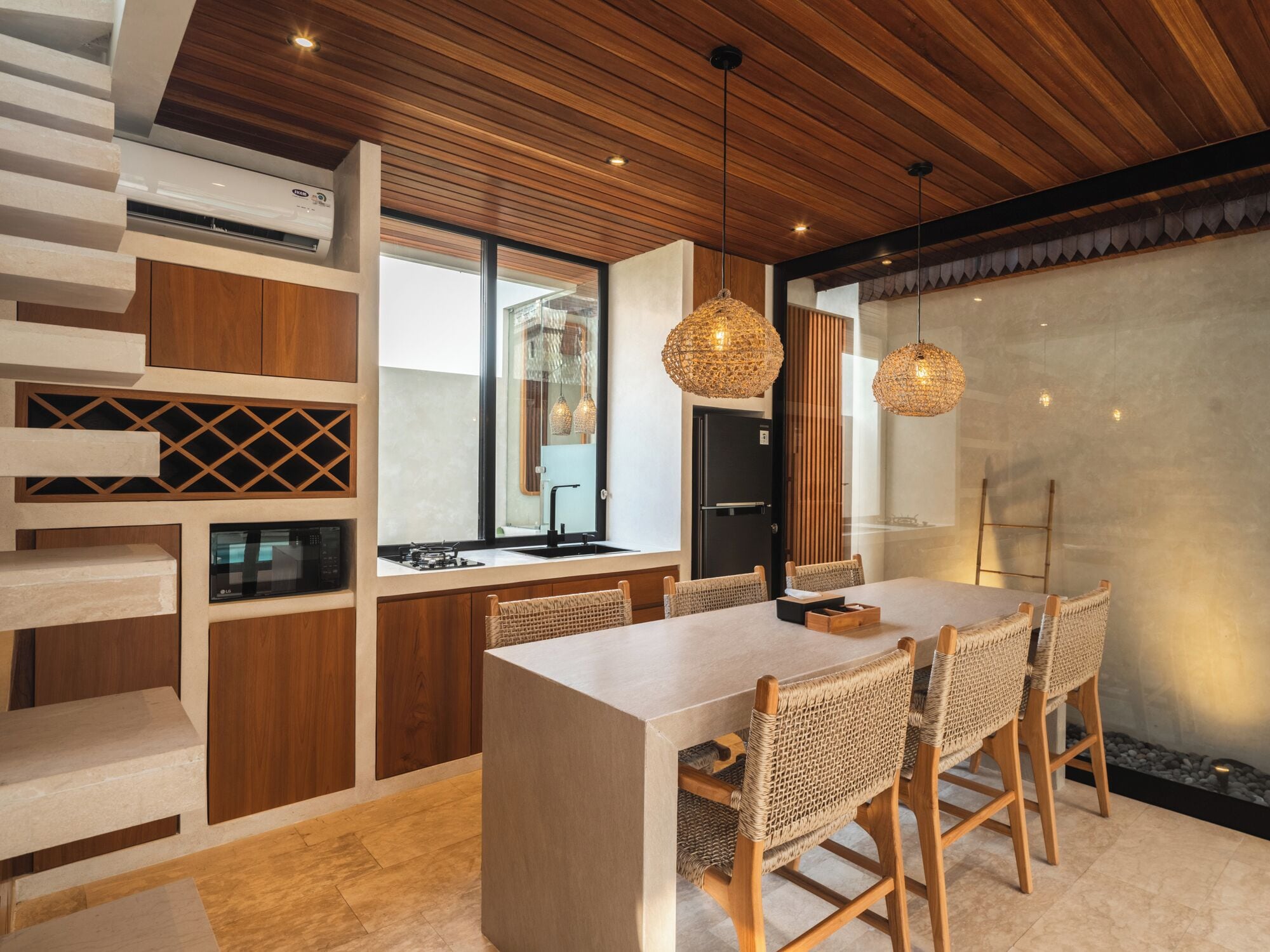 Una cocina moderna con una isla central, armarios de madera y un microondas integrado.