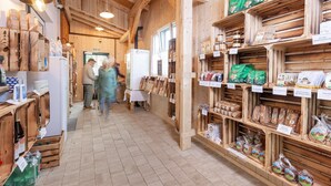A wooden interior with shelves stocked with various food items and a refrigerator. - Chalet near Lake Grundlsee & Ski Lift (Grundlsee)