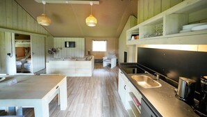 A compact kitchen with a sink, stove, and dining area. - Luxuszelt im Serengeti Park (Hodenhagen)