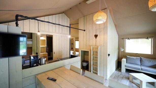 Un espacio habitable compacto con comedor, kitchenette y sofá.