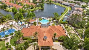 An aerial view of a resort with a central building, a swimming pool, and a lake. - Amazing 3BR 2BA Townhome With Lake View at Terra Verde! (Kissimmee)