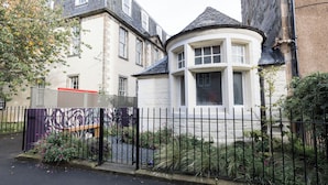 A traditional building with a curved tower and a gated entrance. - JOIVY Contemporary Cottage with Parking (Edinburgh)