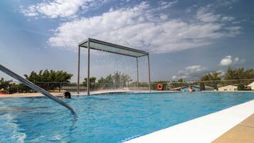 Una piscina con fuente, rodeada por una cerca y un flotador salvavidas.