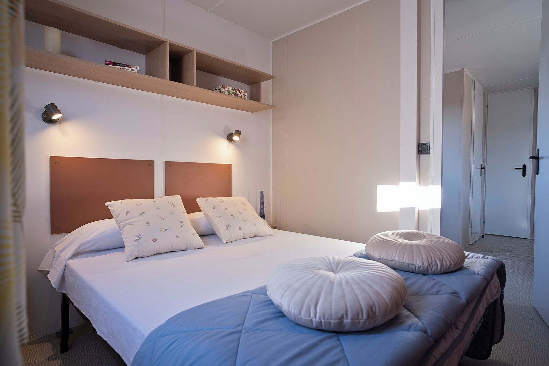 Une chambre d’hôtel comprenant un lit, deux lampes de chevet, une table de chevet et une armoire.