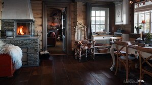 A rustic interior with a stone fireplace, wooden beams, and a cozy seating area. - Luxury Cabin at Nesfjellet with sauna, bbq, close to ski & golf (Nesbyen)
