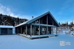 A modern cabin with a sloped roof, large windows, and a covered porch area. - New cabin Vestlia Skeikampen ski-in/out X-skiing (Gausdal)