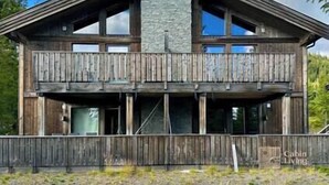 A cabin with a stone fireplace, wooden balcony, and a rustic design. - Sjusjøen ski in/out, ski storage, Wifi, grill & EV-charger, modern apartment! (Sjusjøen)