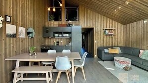 A modern interior with a wooden dining area, a sofa, and a kitchen. - Sjusjøen ski in/out, ski storage, Wifi, grill & EV-charger, modern apartment! (Sjusjøen)