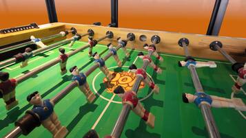 A foosball table with multiple players and a central goal area.