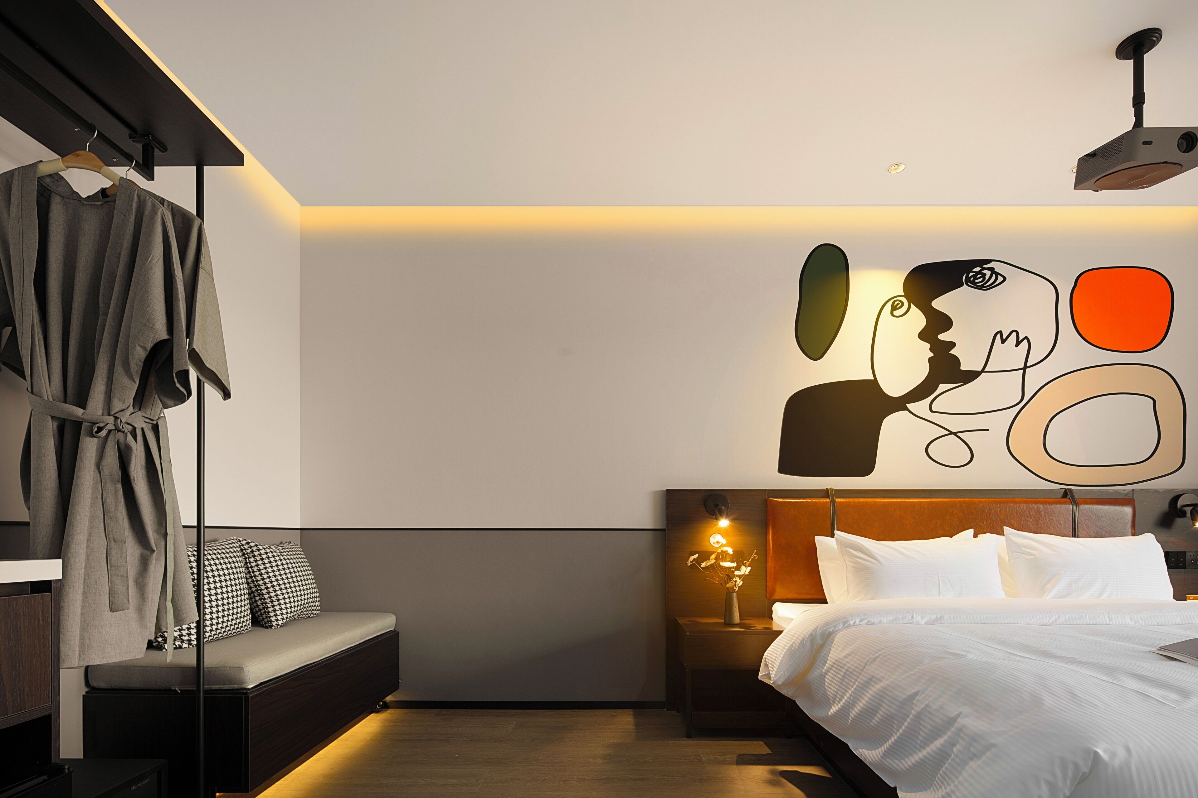 A modern bedroom with a bed, bedside table, and a wall art piece.