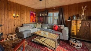 Una sala de estar acogedora con un sofá, una mesa de centro y un aparador.