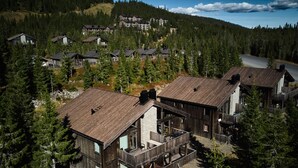 Un resort con chalet in legno, una seggiovia e montagne sullo sfondo.