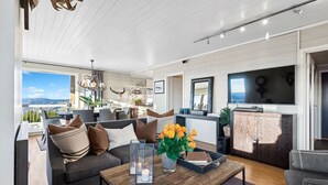 A modern living room with a sofa, coffee table, and a view of the outdoors. - Ski in/out, bbq, mountain view & fireplace - Hafjell (Øyer kommune)