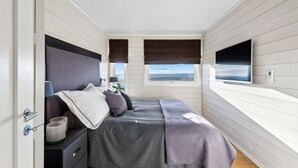 A bedroom with a bed, bedside tables, a lamp, a window, and a TV. - Ski in/out, bbq, mountain view & fireplace - Hafjell (Øyer kommune)
