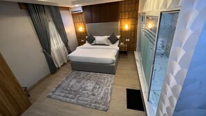 Une chambre moderne avec un lit, des tables de chevet, un tapis et une grande fenêtre avec des rideaux.