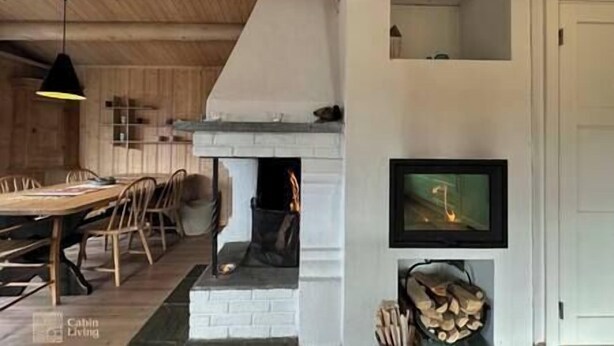 Una sala de estar acogedora con chimenea, una mesa de comedor y sillas.