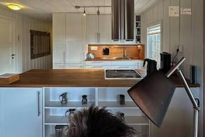 Kitchen features a stove, sink, and coffee maker.