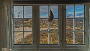 Una habitación con un ventanal amplio que da a un paisaje.