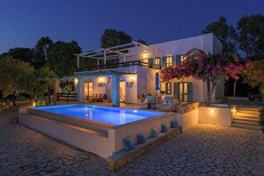 A modern house with a swimming pool, outdoor seating, and a covered patio area. - Villa Mary's Holiday House (Rhodes)