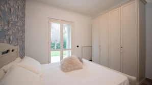 Una camera da letto con un letto, una finestra, un termosifone e un armadio.