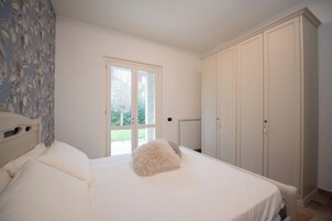 Ein Schlafzimmer mit Bett, Fenster, Heizkörper und Kleiderschrank.