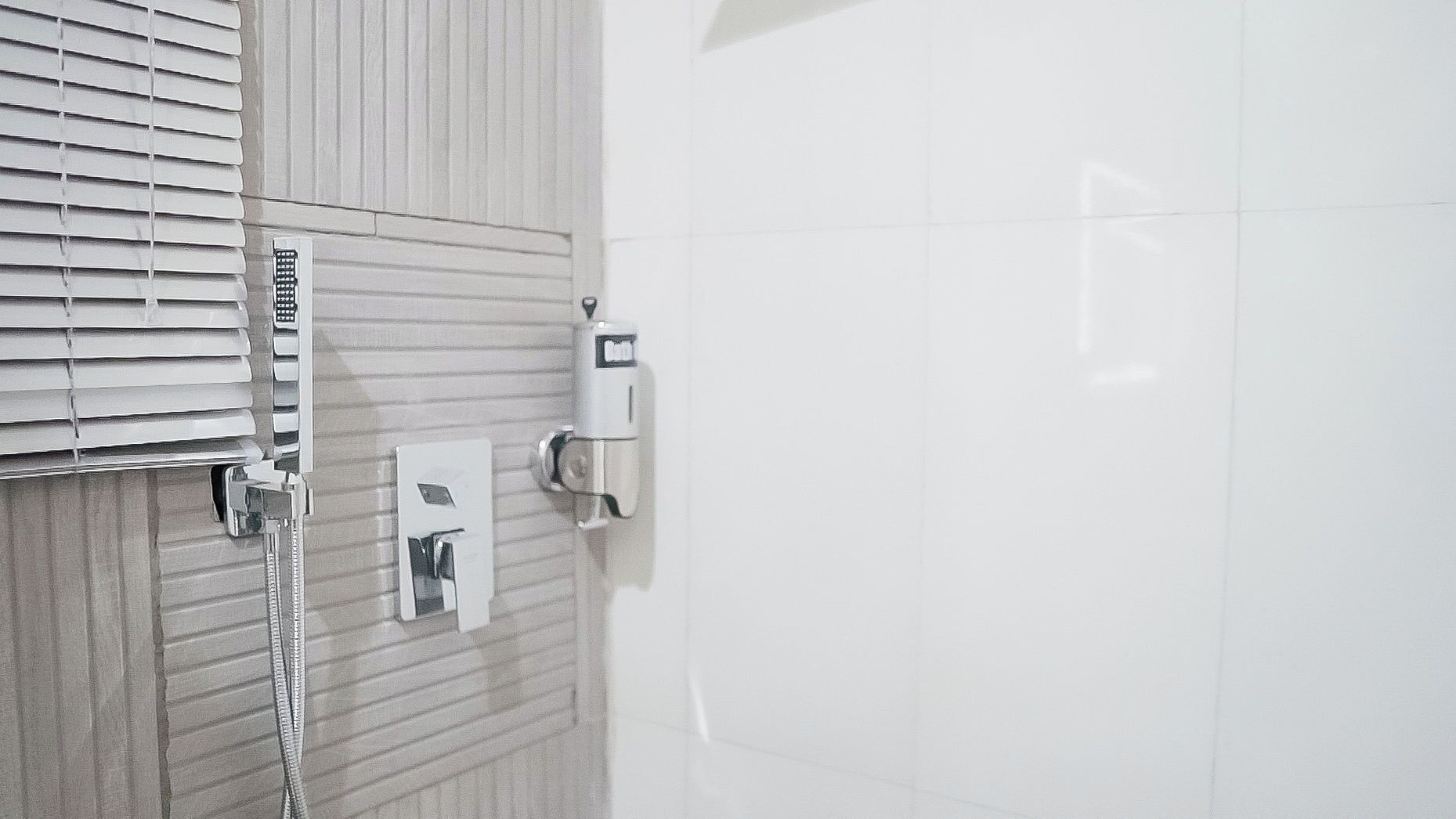 Een badkamer met een douche, toilet en handdroger.