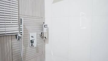 Een badkamer met een douche, toilet en handdroger.