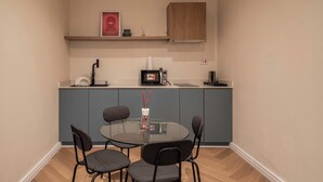 A compact kitchen with a dining table and chairs, a microwave, and a small cabinet above the counter. - *NEW* Studio with King Size Bed in Lekki 1 (Lekki)