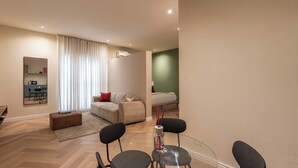 A modern living room with a glass dining table, a sofa, and a coffee table. - *NEW* Studio with King Size Bed in Lekki 1 (Lekki)