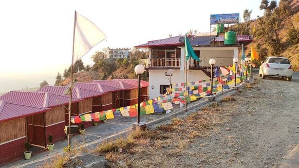 Un bâtiment comportant plusieurs pièces, un drapeau et une voiture garée à proximité.