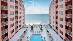 Ein Hotel mit Pool, Balkonen und Blick auf den Strand.