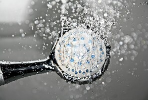 Primer plano de una gota de agua con un asa negra, rodeada de gotas más pequeñas.