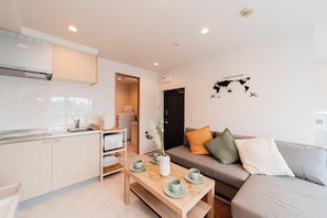 Departamento empresarial, varias camas, vista a la ciudad | Área de sala de estar | Televisión LCD de 25 pulgadas con canales por cable