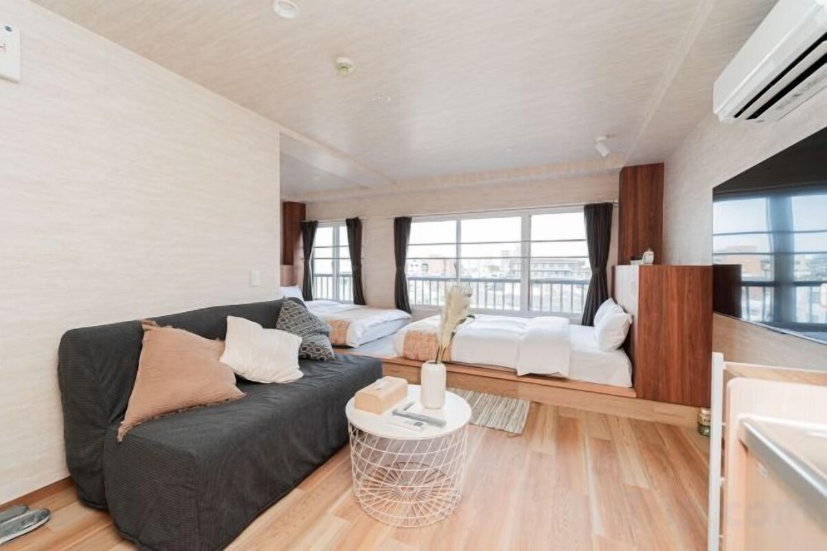 A modern room with a sofa, a small round table, and a bed.