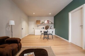 Cozy living space with a leather sofa, kitchenette, and dining area.