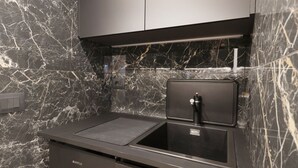 A modern kitchen with a black countertop, a sink, and a built-in oven.