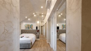 A narrow hotel corridor with two beds, a mirrored wardrobe, and artwork on the walls. - GARIBALDI, 64 – In the heart of the historic center (Milano)