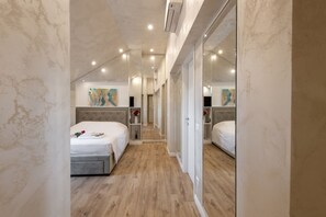 A narrow hotel corridor with two beds, a mirrored wardrobe, and artwork on the walls. - GARIBALDI, 64 – In the heart of the historic center (Milano)