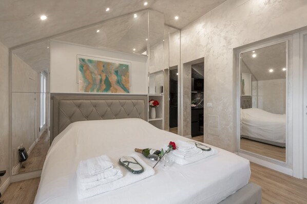 Un dormitorio moderno con una cama grande, un espejo y un cuadro en la pared.