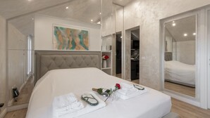 A modern bedroom with a large bed, a mirror, and a painting on the wall. - GARIBALDI, 64 – In the heart of the historic center (Milano)